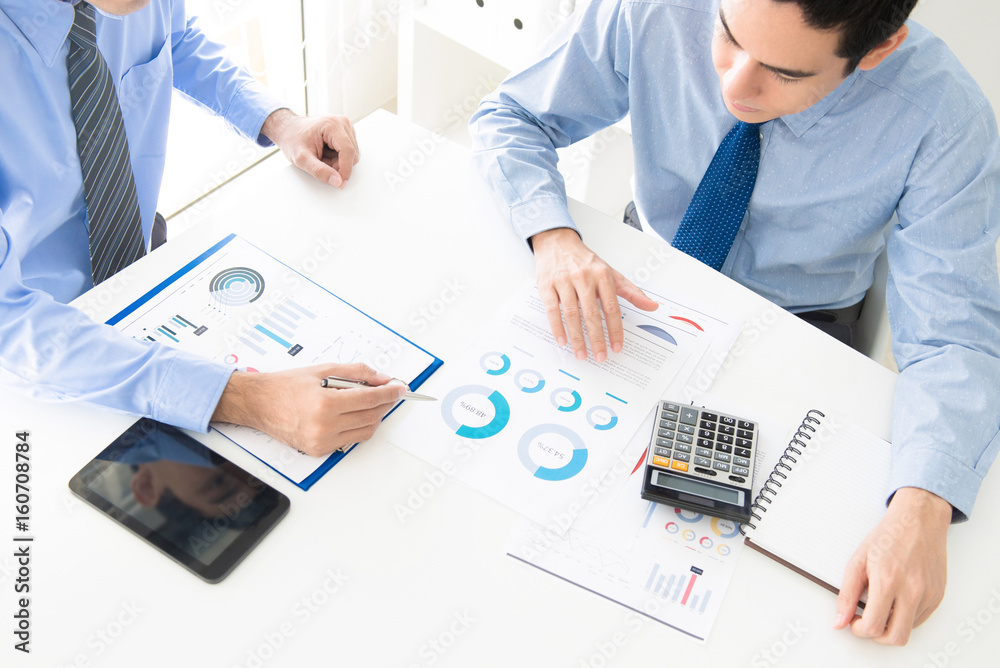 Business people discussing and analyzing financial documents Business people discussing and analyzing financial documents