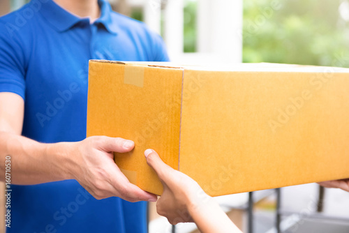Wallpaper Mural Delivery man in blue uniform handing parcel boxes to recipient Torontodigital.ca