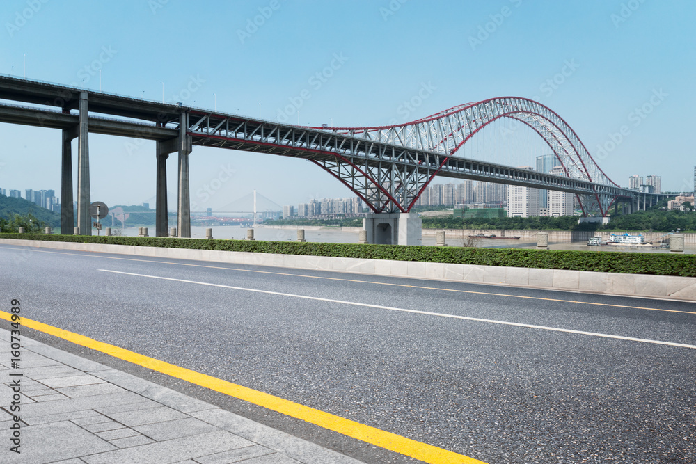 empty road near steel bridge in modern city