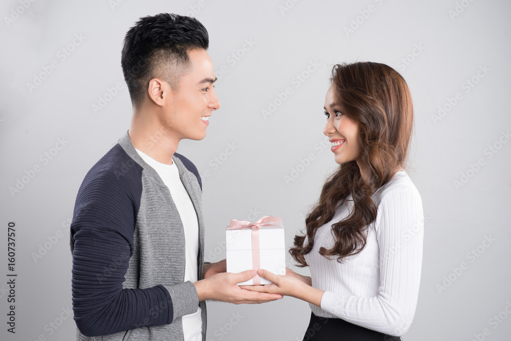 Happy smiling couple in love standing over gray background.