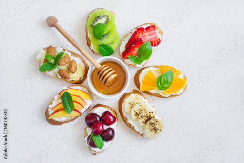 selection summer sweet snacks. Bruschetta or sandwiches with fruit and berries. Top view with copy space