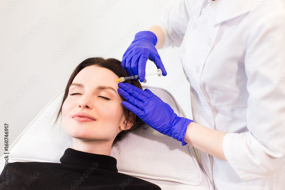 Naklejka premium A woman on the procedure of injections in a cosmetology clinic