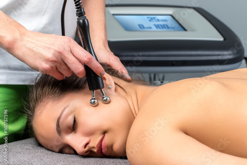 Female patient receiving electrotherapy  therapy on face. photo