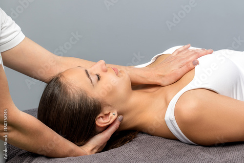 Woman receiving osteopathic neck treatment.