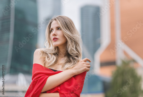 Outdoors portrait of beautiful young woman in red. Selective focus.