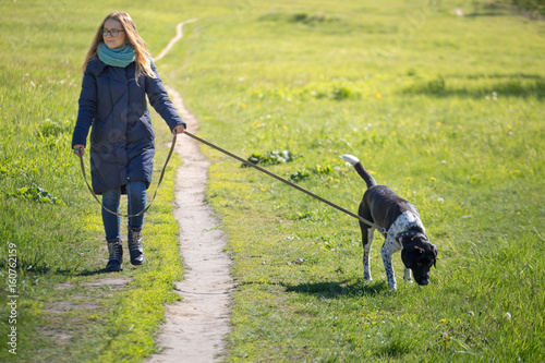 Beautiful girl with a dog on a walk.