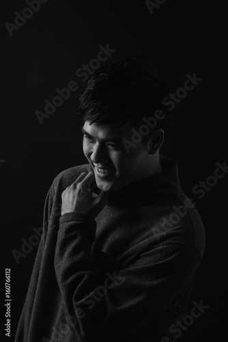 Young asian man's portrait against black background