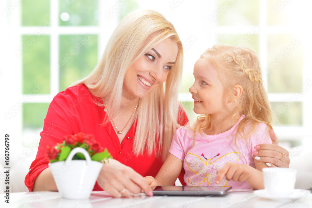  woman and little girl using  tablet