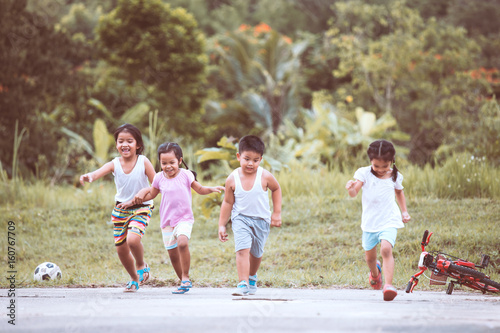 Asian children having fun to run and play together in the field in vintage color tone