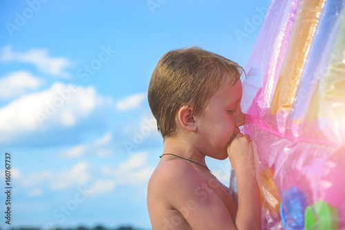 Obraz na płótnie The boy blows the beach mattress