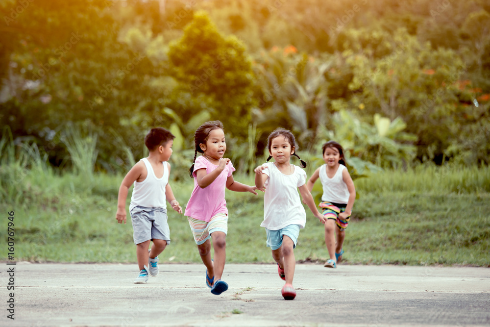 Asian children having fun to run and play together in the field in vintage color tone
