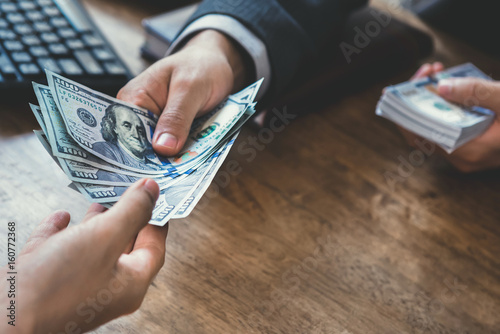 Canvastavla Businessman giving money to a man at working desk