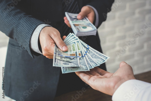 Businessman giving or paying money to a man