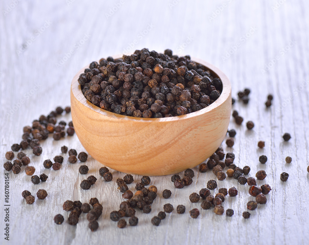 Black peppercorns on white wooden background Black peppercorns on white wooden background