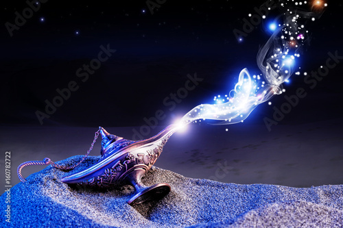  magical aladdin lamp with smoke coming out in a night resting on the dunes of a desert. magical and evocative atmosphere. photo