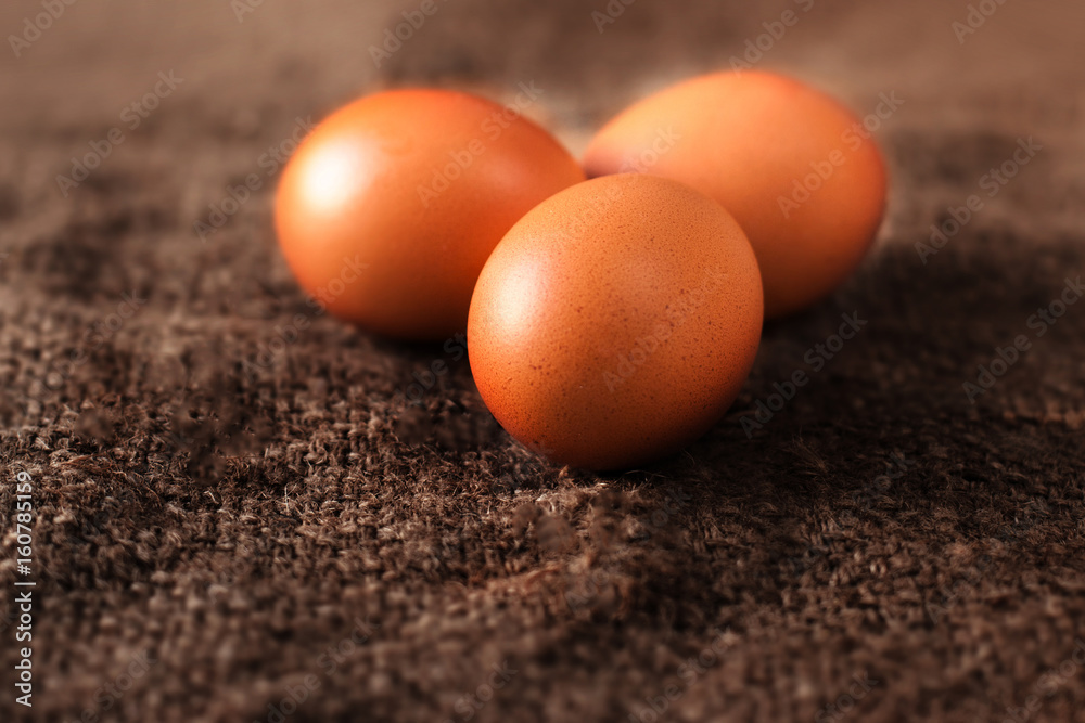 Heap of fresh brown Eggs on wooden background closeup image in dark orange colors Heap of fresh brown Eggs on wooden background closeup image in dark orange colors