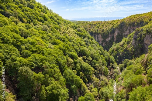 Mountains and forest in canyon Okazio in mountains against blue sky. Georgia.