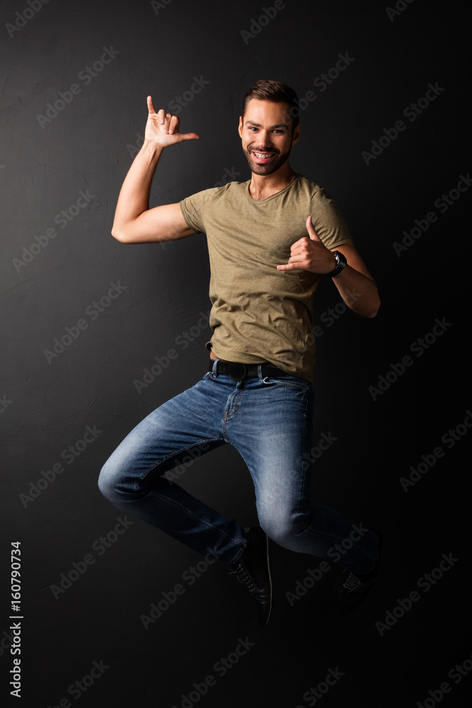 Happy handsome young man jumping and dancing