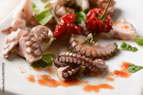 Fotografi Octopus with seasoning on white dish