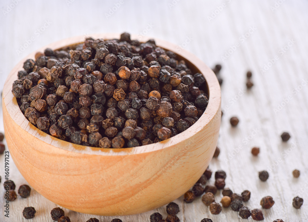 Black peppercorns on white wooden background Black peppercorns on white wooden background