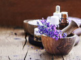 Lavender spa , bunch of lavender flowers , essential oil and salt on a rustic wooden background.