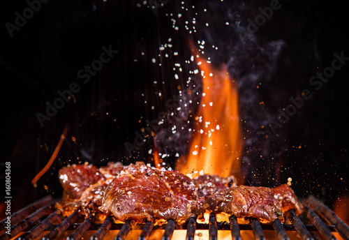 Beef steaks on the grill with flames