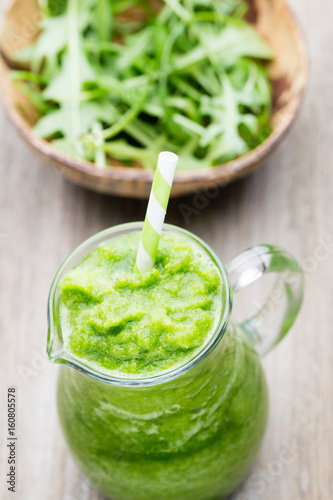 Rucola smoothie, on the grey  background.