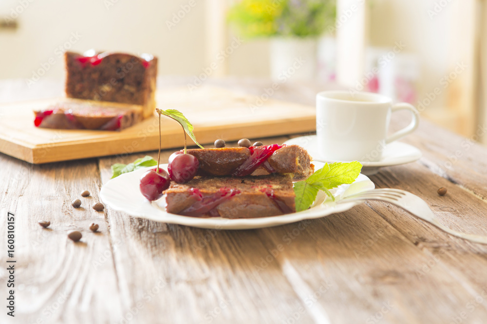 Delicious chocolate cake on plate and cutting board on brown rustic table background Delicious chocolate cake on plate and cutting board on brown rustic table background