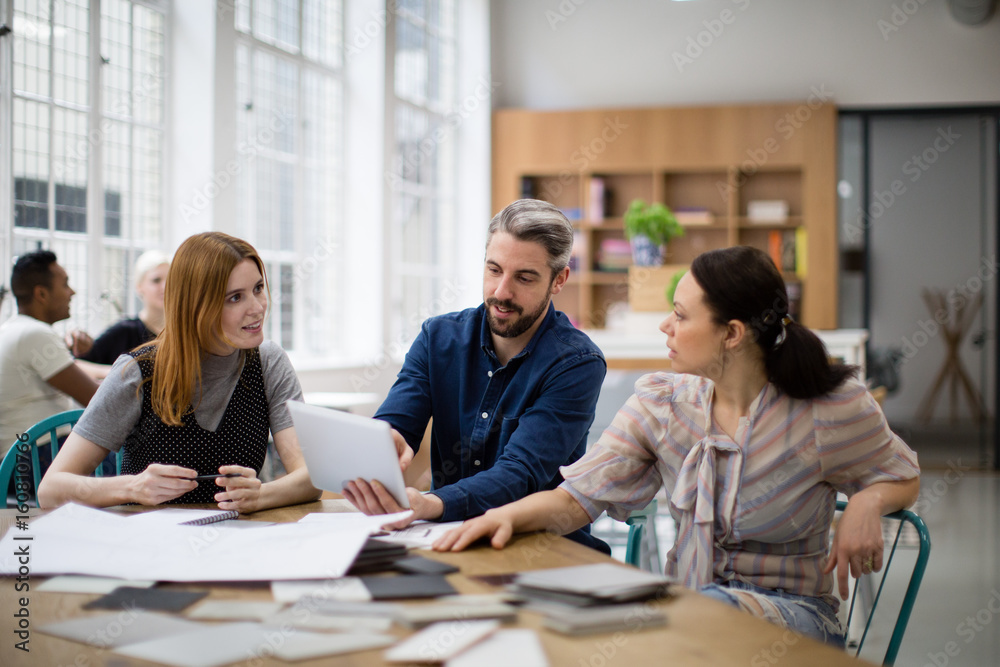 Group of coworkers discussing a project Group of coworkers discussing a project