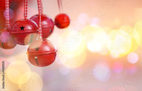 Jingle bells on blurred Christmas lights background, closeup