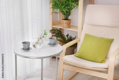 Beautiful modern veranda with cozy armchair and coffee table
