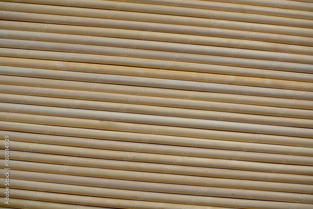 A pattern of many parallel wooden round sticks, closely pressed together to one another A pattern of many parallel wooden round sticks, closely pressed together to one another
