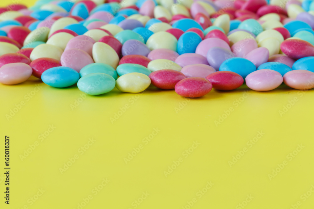 Obraz premium Colorful candies on yellow background