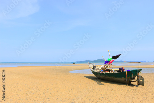 Beautiful blue sky on the wooden fishing boat on a sand beach