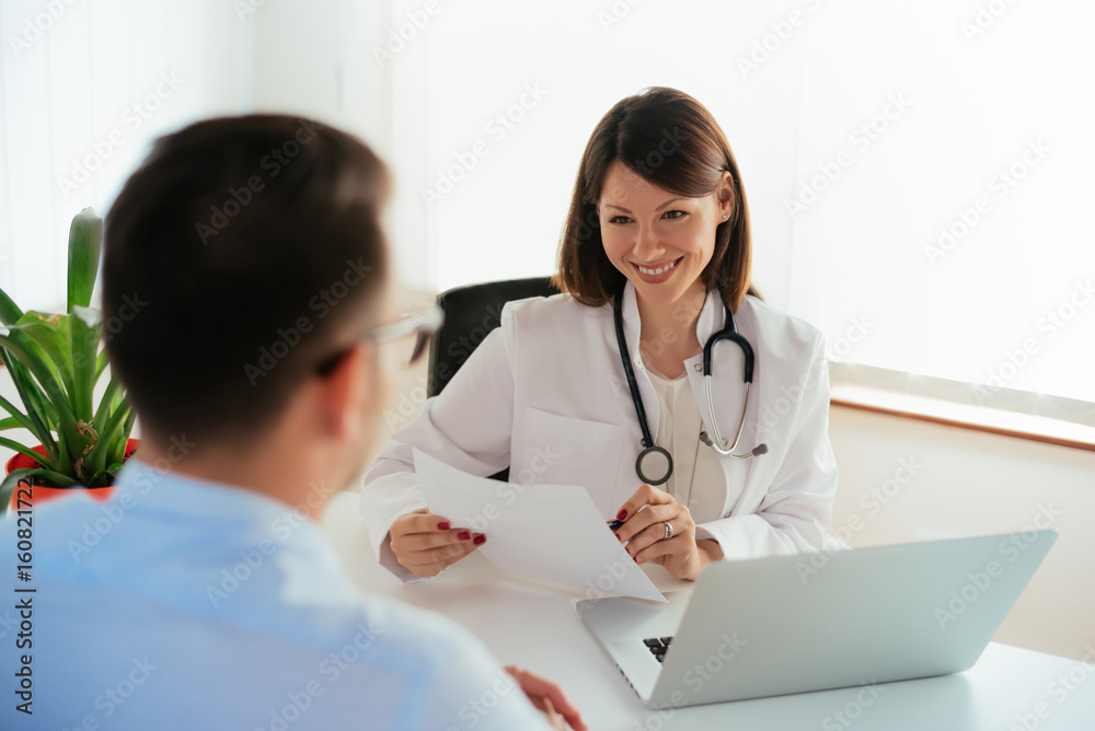 Smiling female doctor reporting medical results to male patient. Smiling female doctor reporting medical results to male patient.