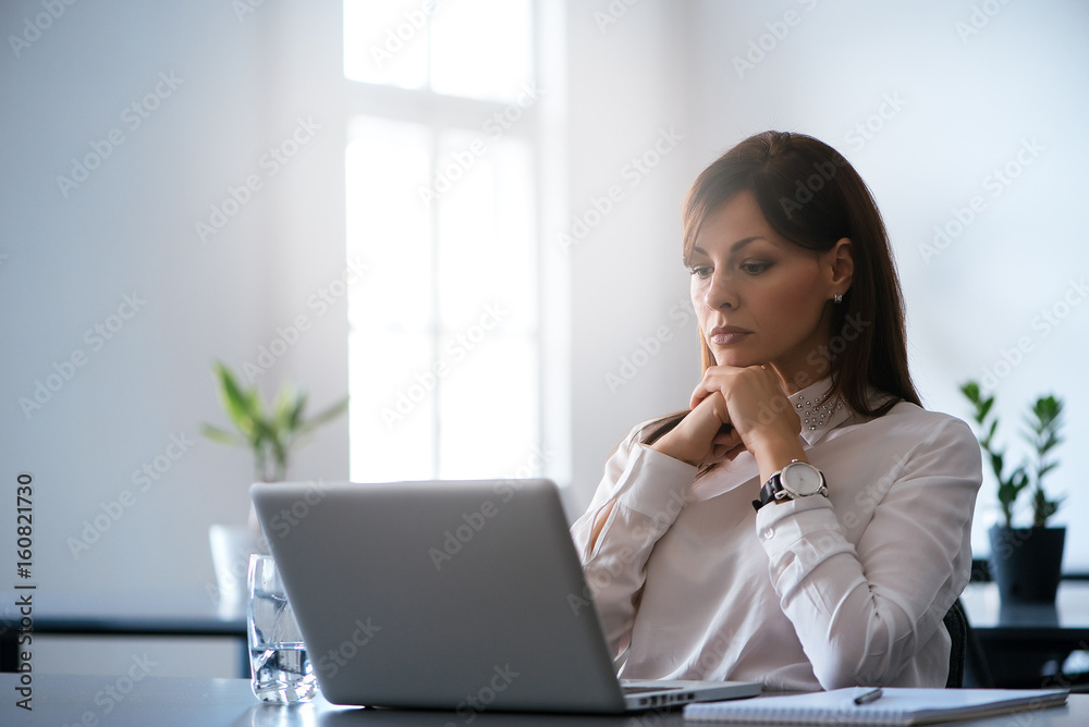 Young woman in the office working with a laptop Young woman in the office working with a laptop