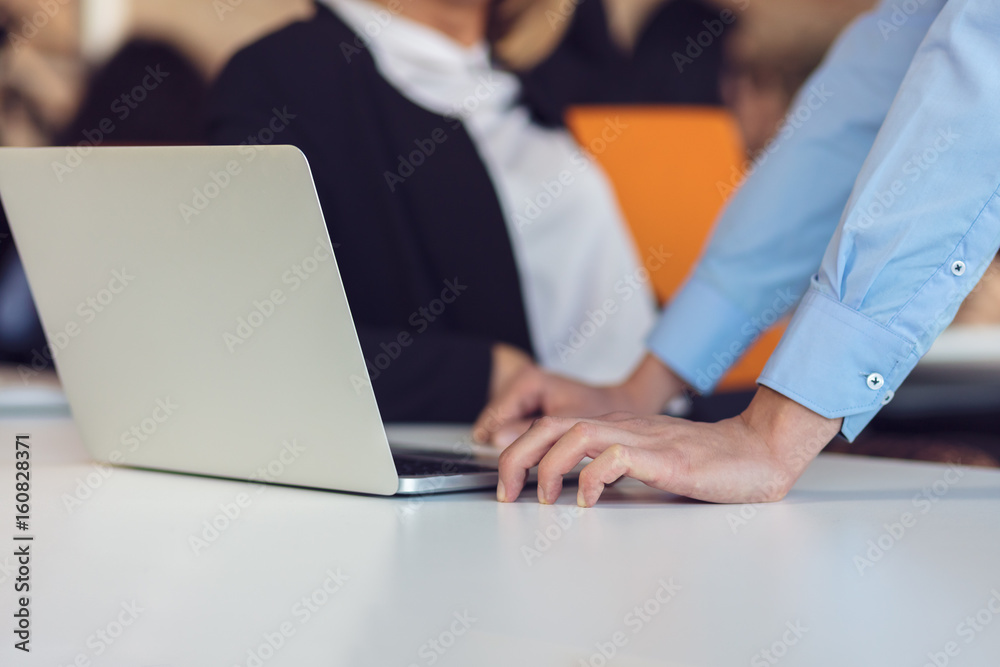 Colleagues chatting, sitting together at office table, smiling Colleagues chatting, sitting together at office table, smiling