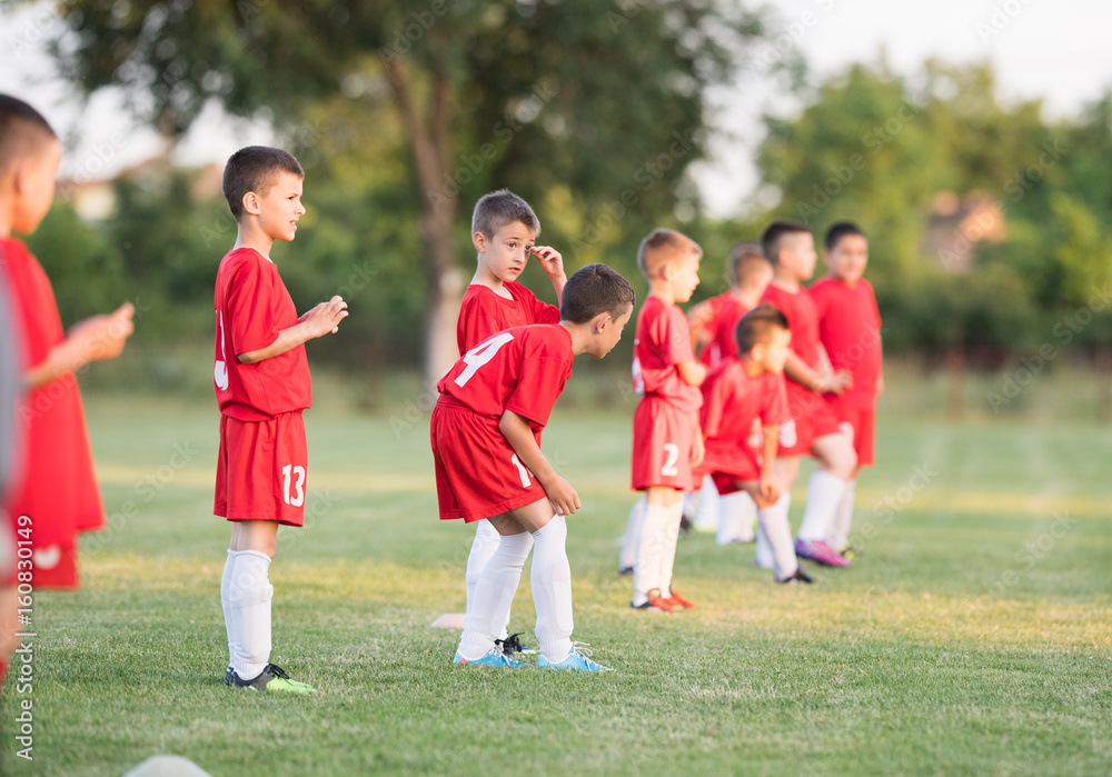 Obraz premium Kids soccer football - children players exercising before match on soccer field
