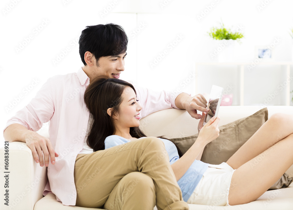smiling young couple watching the tablet smiling young couple watching the tablet