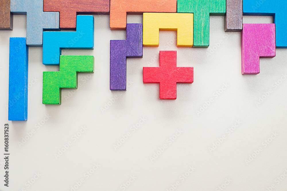 Obraz premium Different colorful shapes wooden blocks on beige background, flat lay. Geometric shapes in different colors, top view. Concept of creative, logical thinking or problem solving. Copy space.