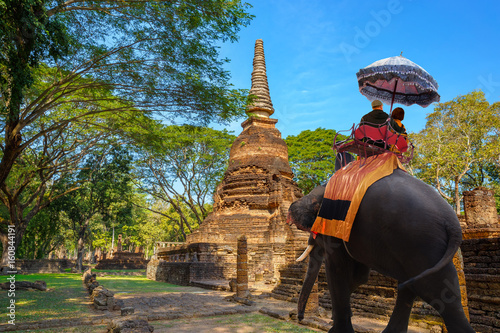 Tourists with elephant at Wat Nang Phaya in Si Satchanalai Historical Park, a UNESCO World Heritage Site in Thailand