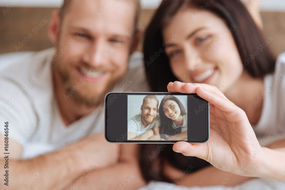 Young couple taking self portrait picture with smartphone