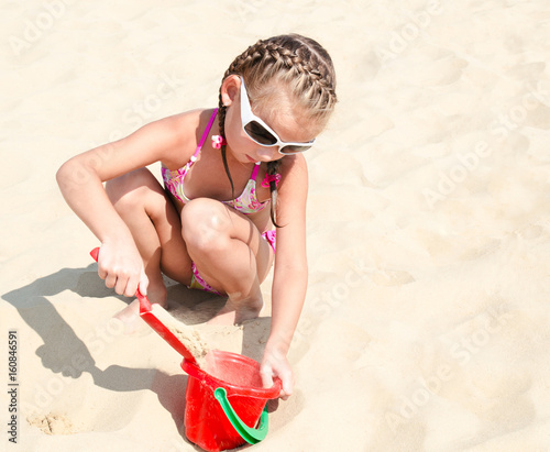 Cute smiling little girl playing on beach