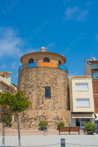 Old tower in the Spanish town on the waterfront street of Cambri