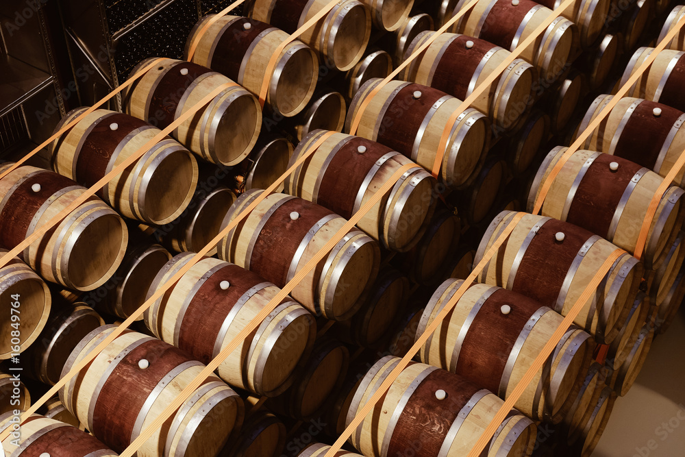 Oak wine barells stacked in modern winery. View from above