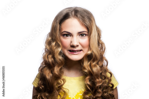 Portrait of crazy angry girl with wavy hairstyle and yellow t shirt. studio shot isolated on white background.