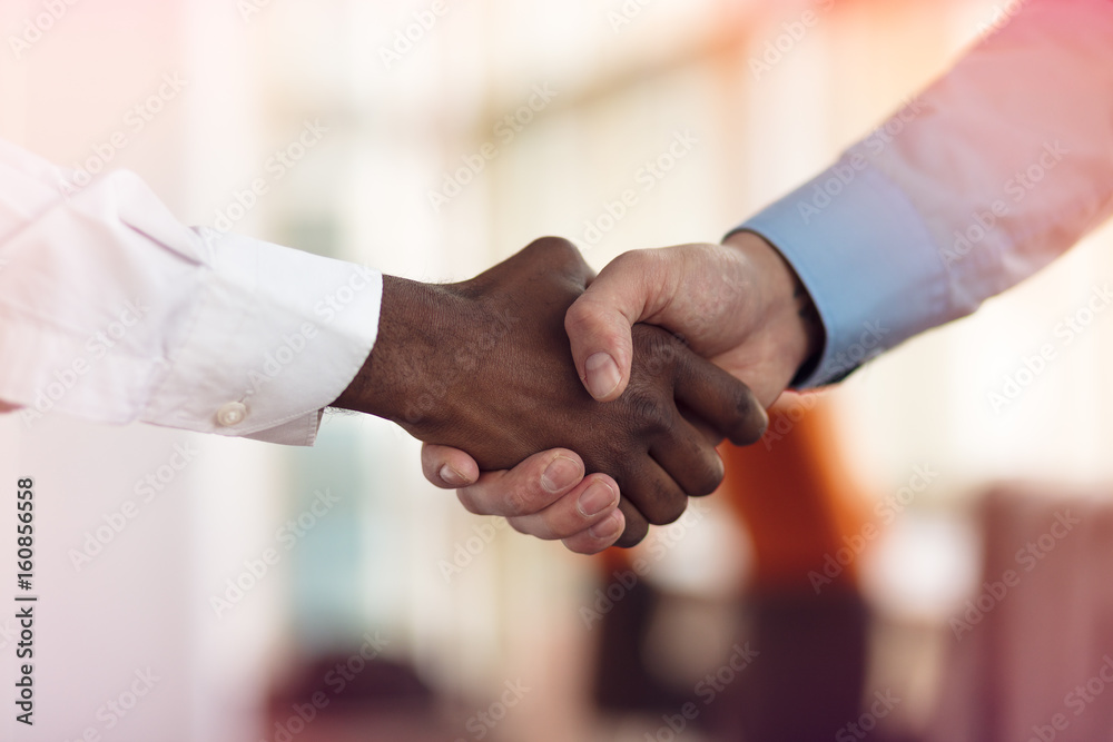 Handshake between african and a caucasian man Handshake between african and a caucasian man