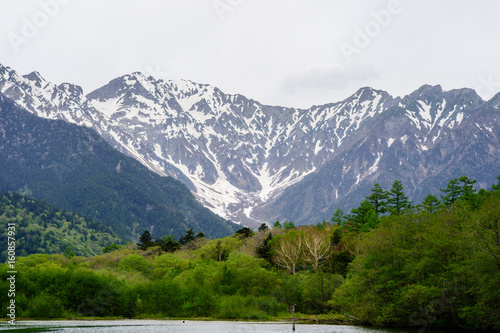 Hotaka mountain range and taisho ike pond in spring at kamikochi national park nagano japan