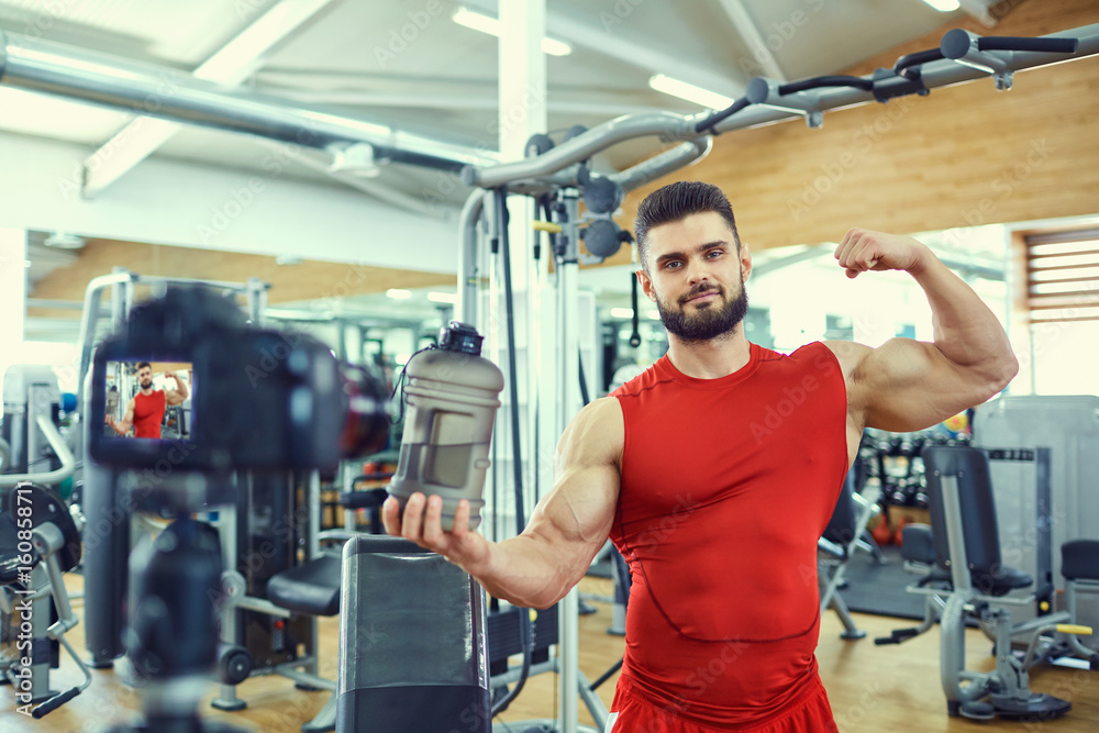 Vlogger sportsman makes a video in the gym. Vlogger sportsman makes a video in the gym.