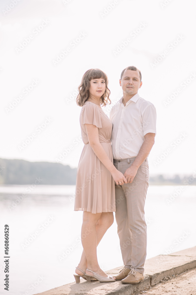 love story, beautiful couple along the river Bank,are holding hands, vertical, blue sky with white clouds, summer, nature love story, beautiful couple along the river Bank,are holding hands, vertical, blue sky with white clouds, summer, nature